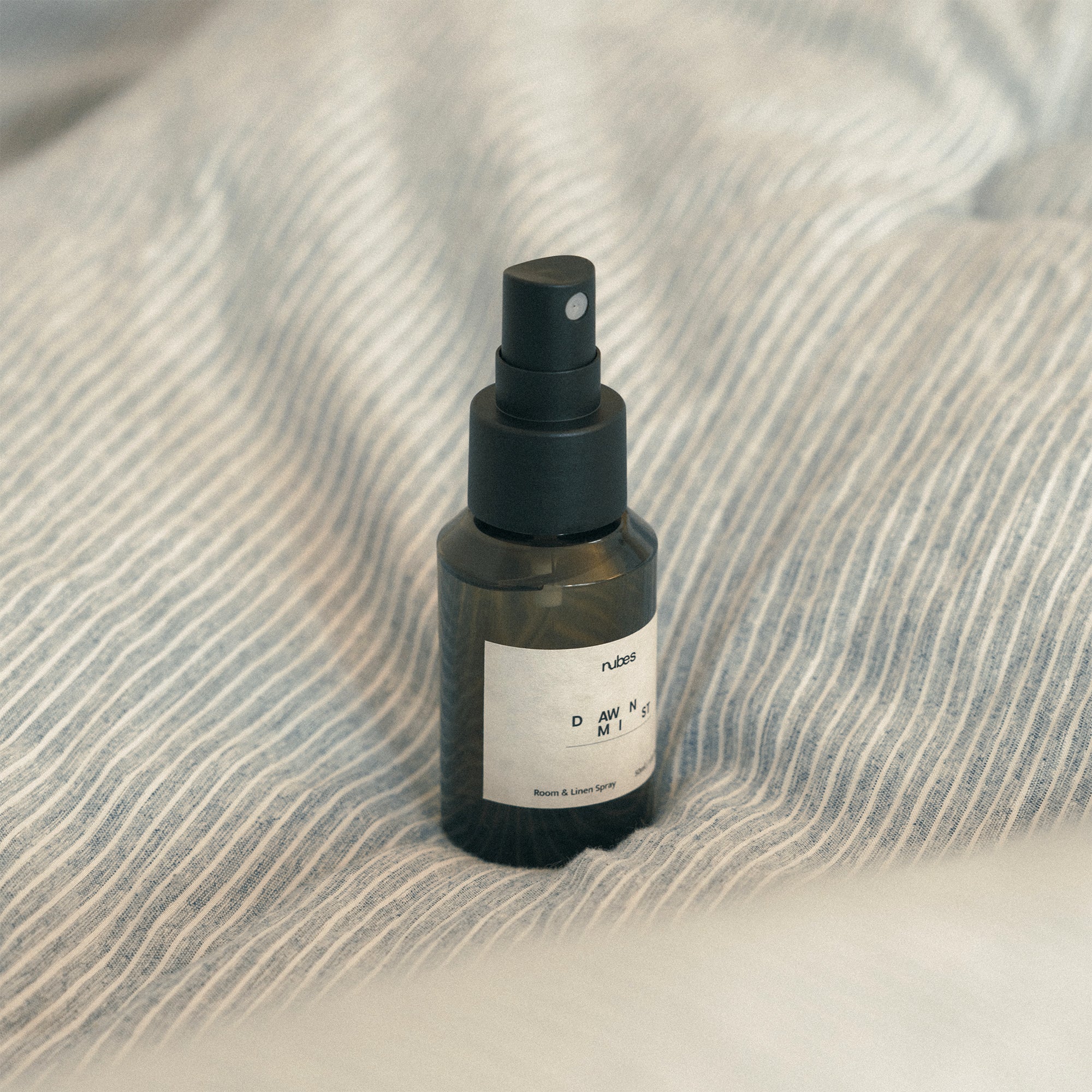 Spray bottle with a spray nozzle on a textured fabric surface