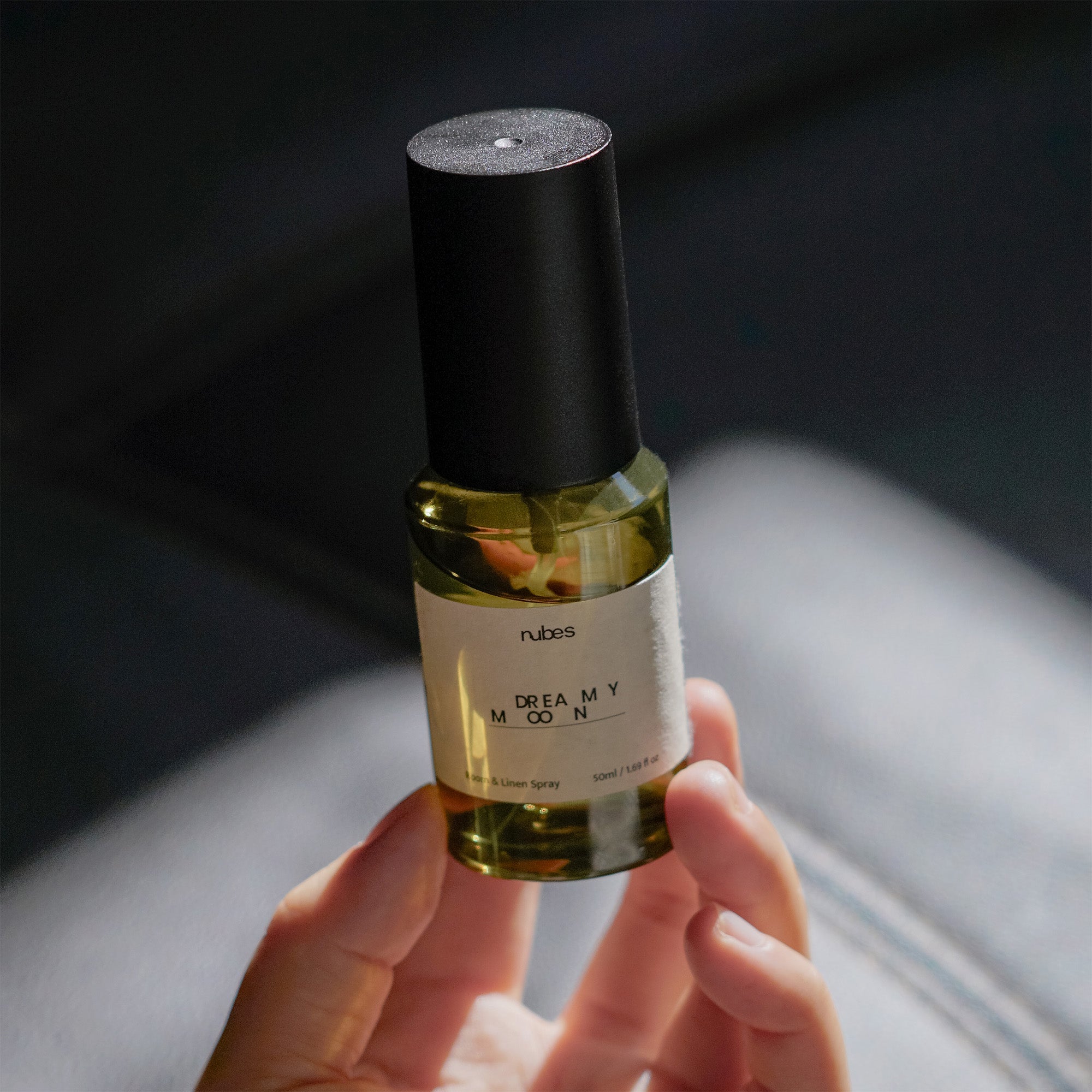 Hand holding a small bottle labeled &