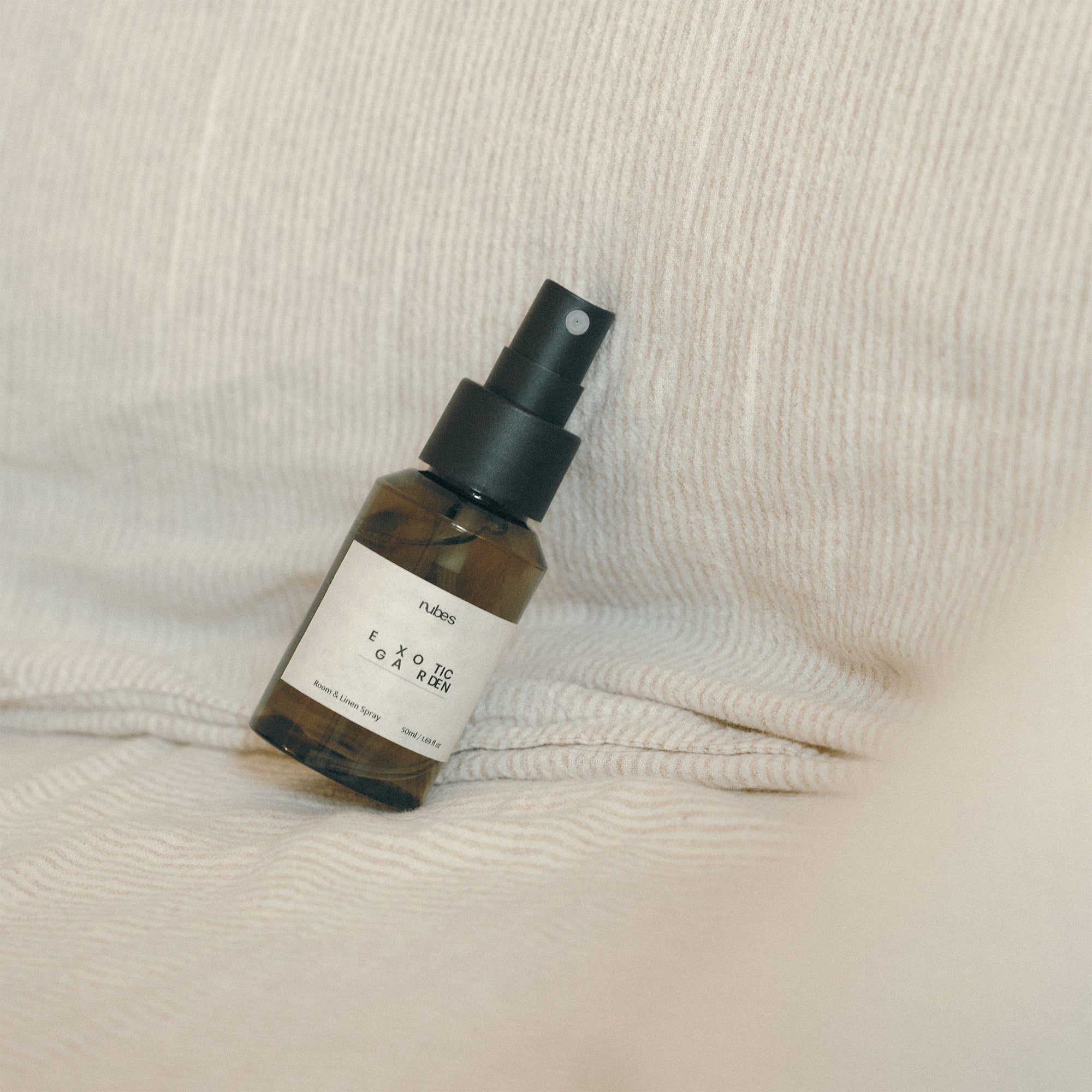 Spray bottle with black spray nozzle on a textured beige surface