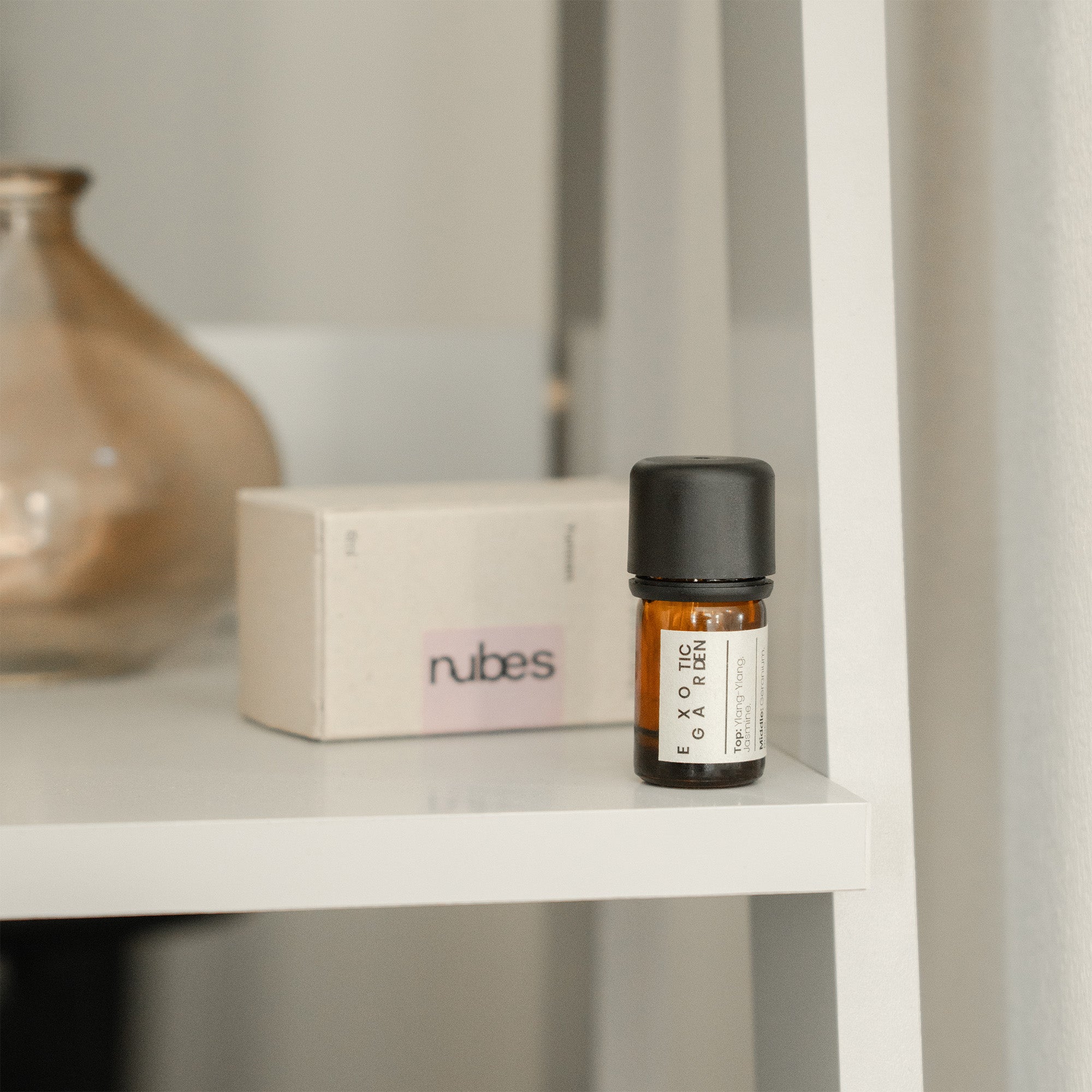 Bottle of Exotic Garden essential oil on a shelf with a box labeled &