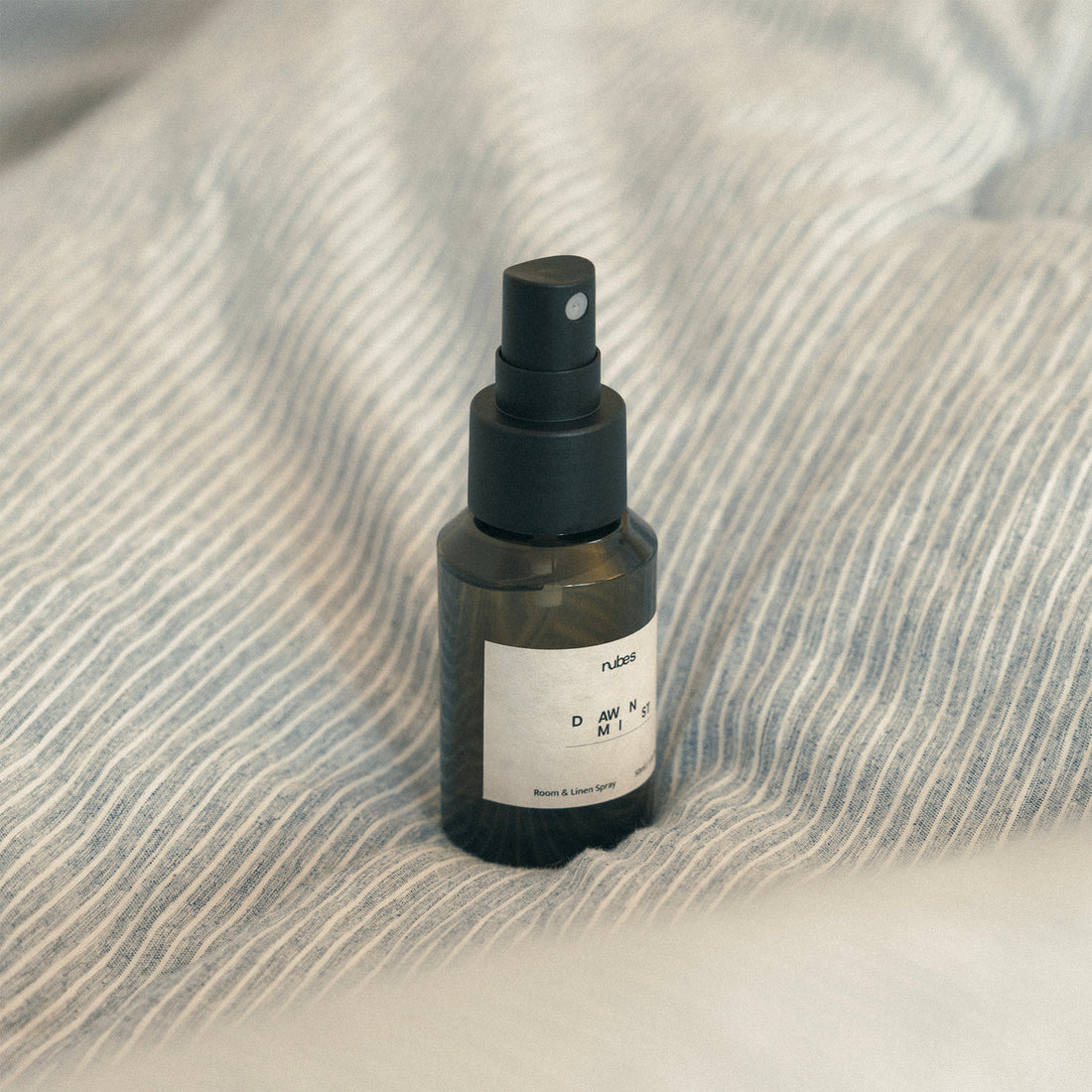 Spray bottle with a spray nozzle on a textured fabric surface