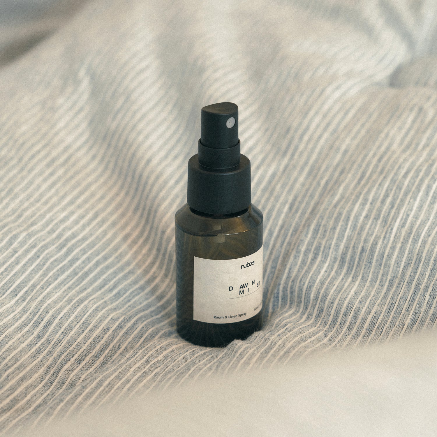 Spray bottle with a spray nozzle on a textured fabric surface
