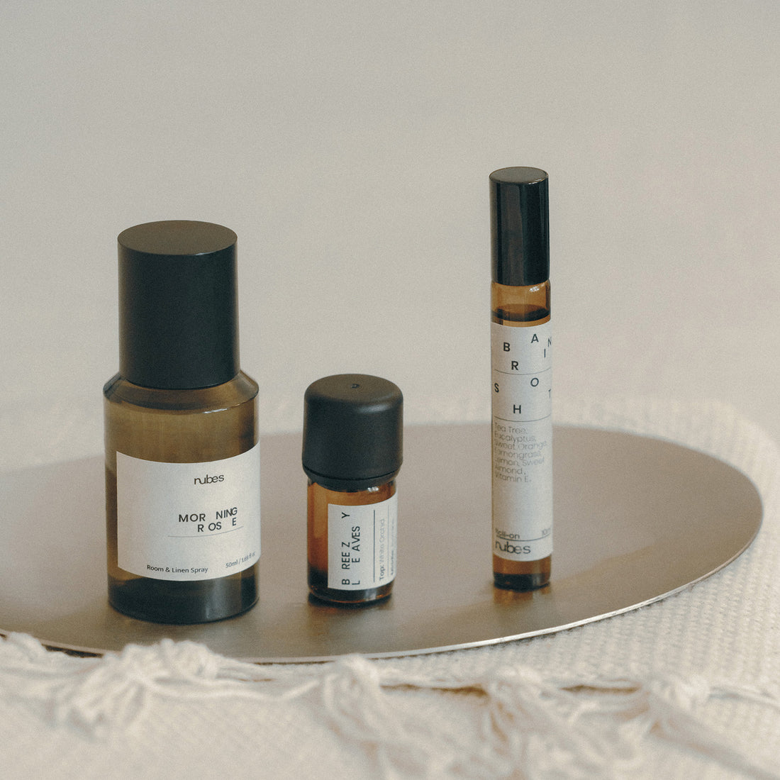 Three small bottles with labels on a reflective surface