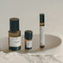Three small bottles with labels on a reflective surface