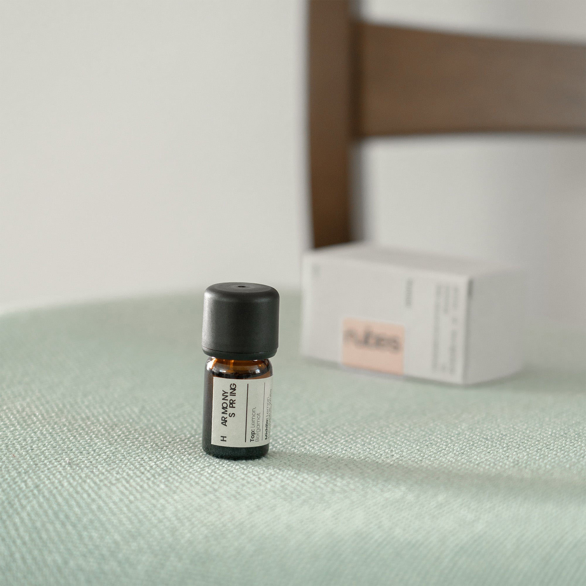 Small bottle with a label on a textured surface, with a blurred box in the background