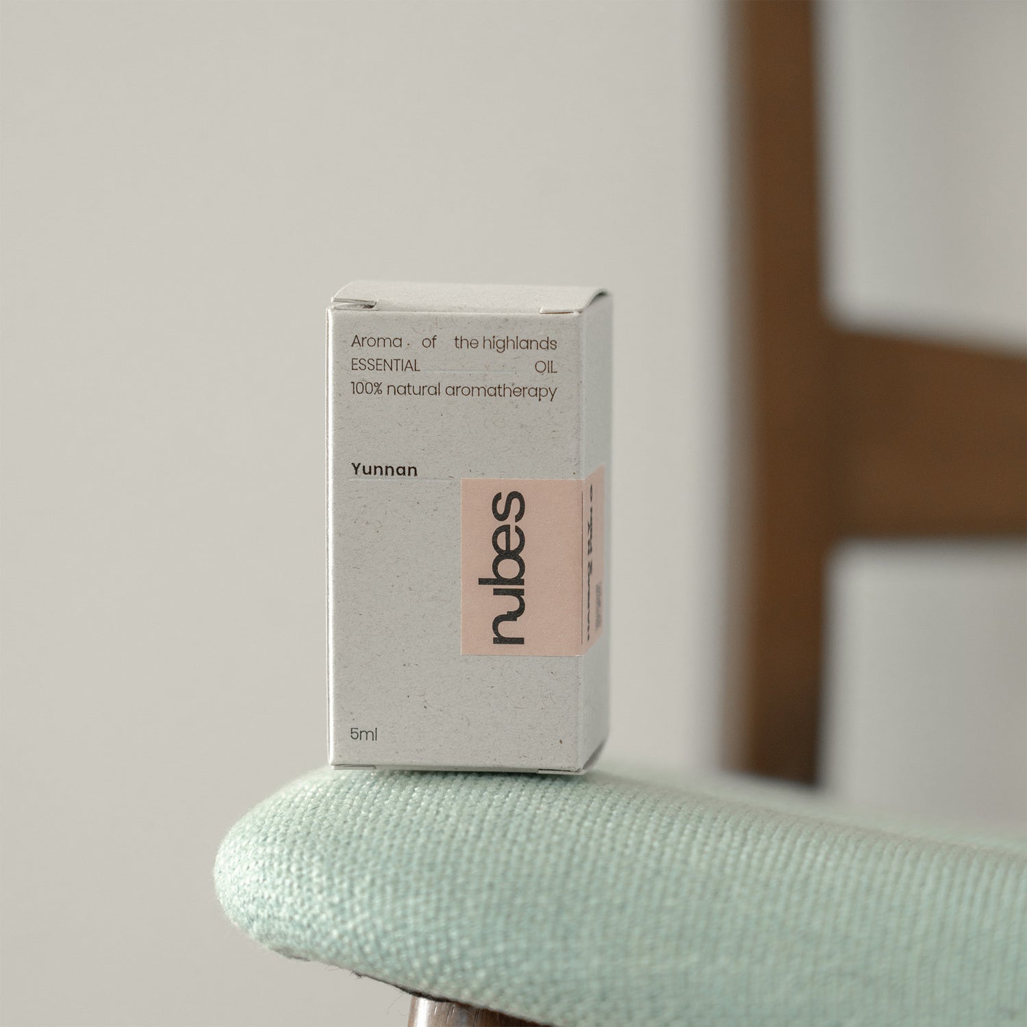 Rubes essential oil box on a light green surface with a blurred background