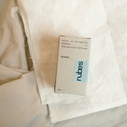 Nubes essential oil packaging on a textured beige fabric background