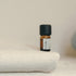Small brown bottle with a black cap on a textured white surface