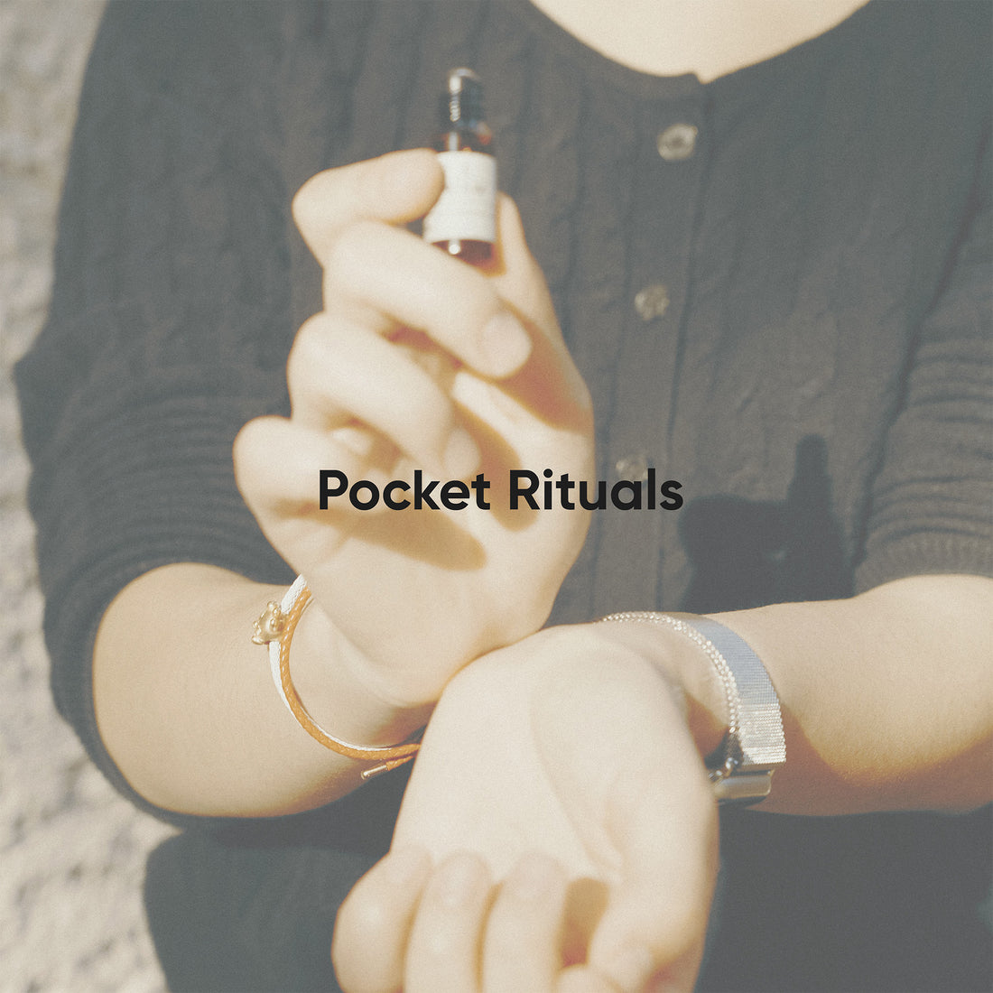 Person holding a small bottle with &
