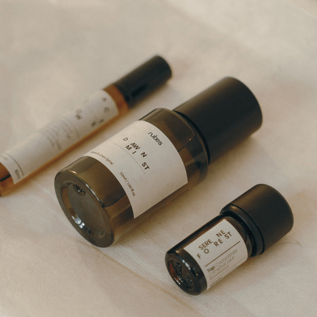 Three small bottles with labels on a light surface