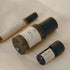 Three small bottles with labels on a light surface