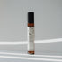 Nubes roll-on essential oil "Peace Flows" standing in soft natural light with striped shadows.