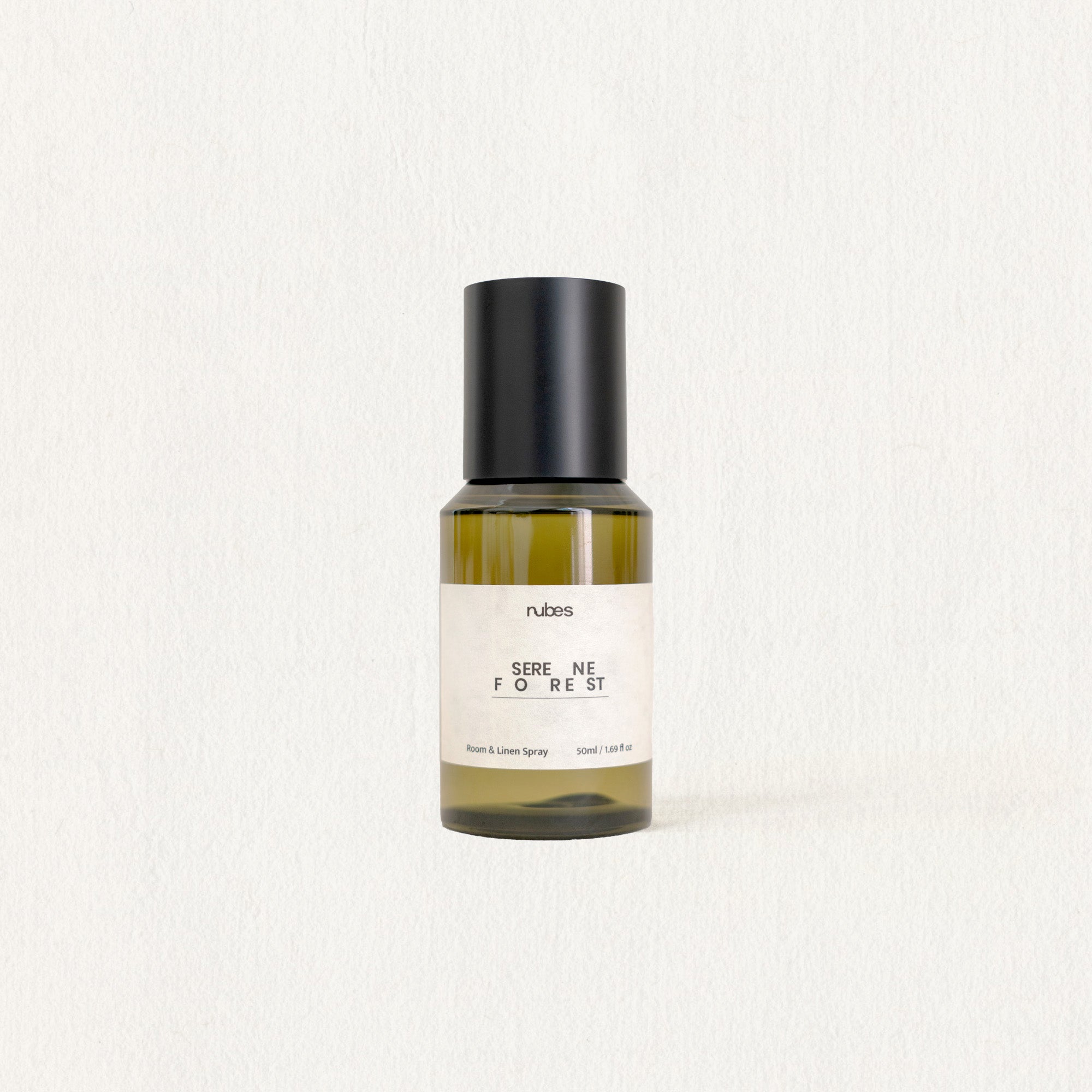 Bottle of 'Serenity Forest' by nubes on a light beige background