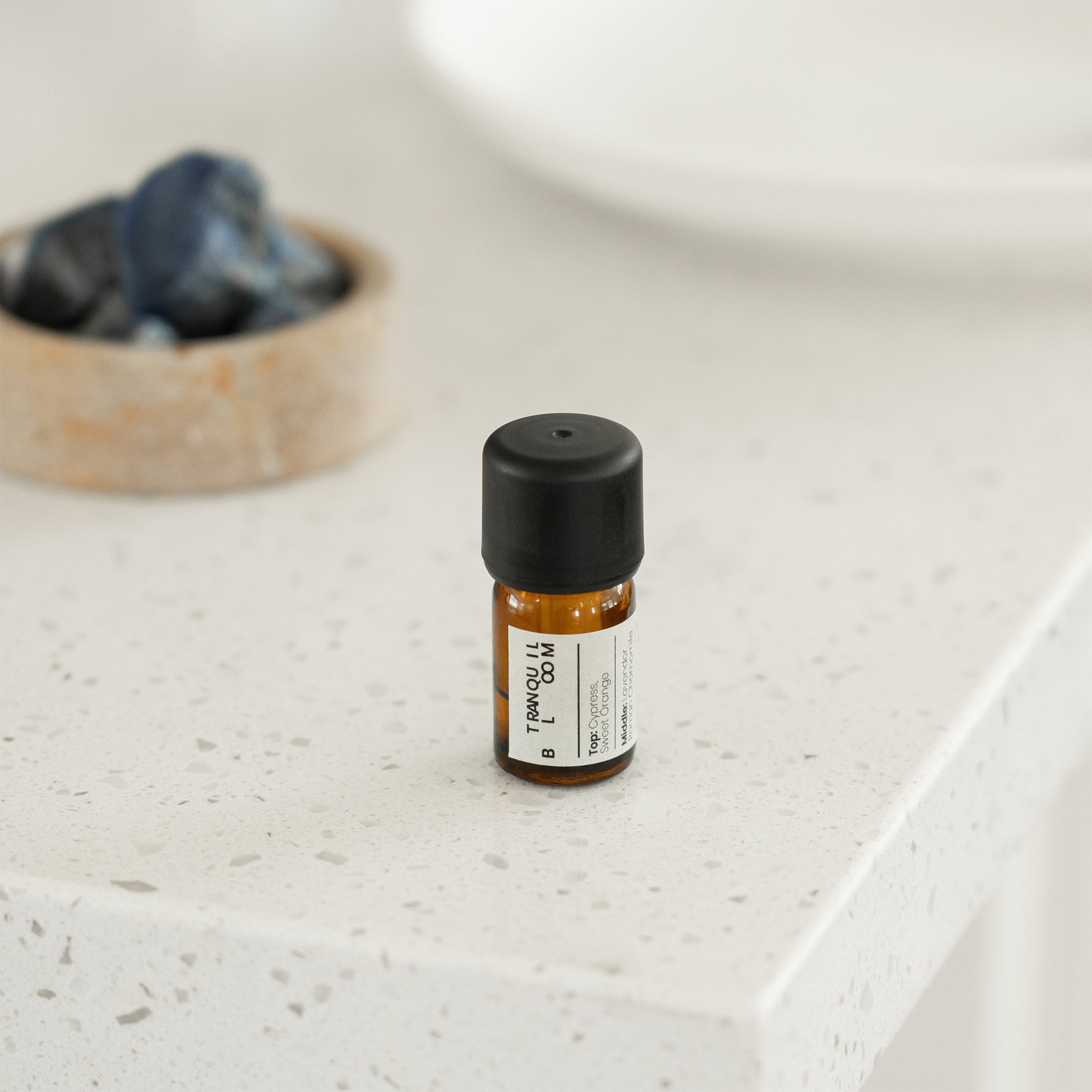 Small bottle with a black cap on a light-colored surface